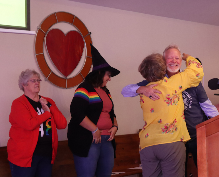 Cath Bolkcom hugs Pastor Rich Hendricks