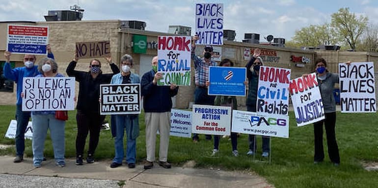 PACG members holding signs at weekly Civil Rights Rally in Moline
