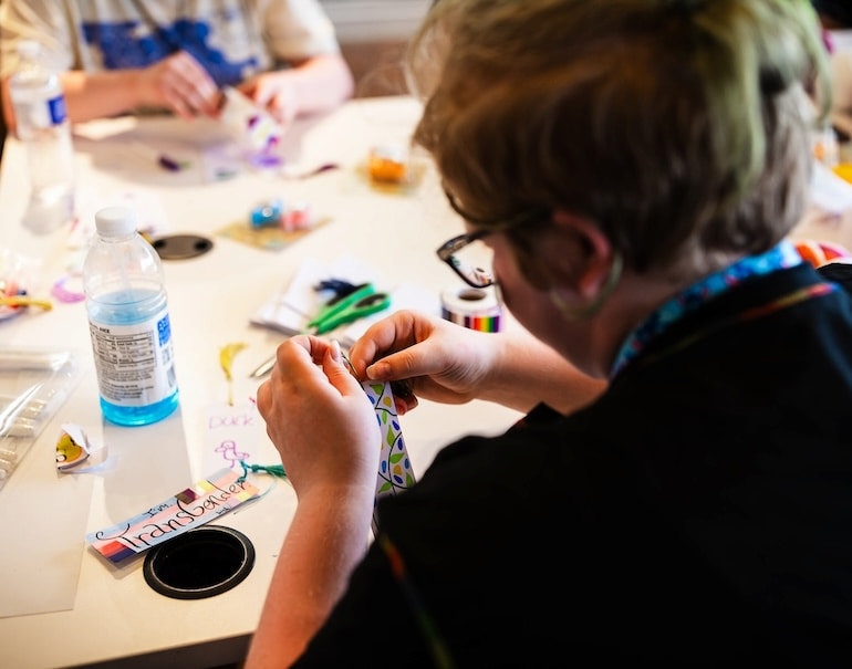 A young student focuses in during Craft Night with Free Mom Hugs at Clock Inc. LGBT+ Community Center.