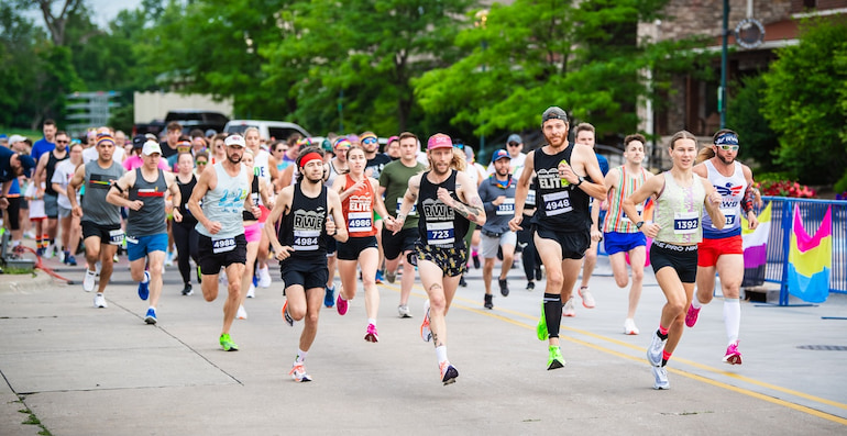 Runners in black jerseys at head of pack during Pride 5K in Moline June 15