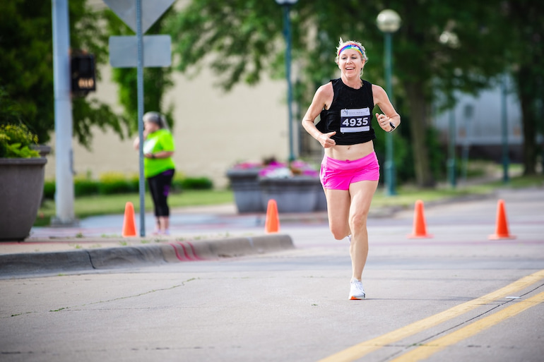 A runner smiles during the Pride 5K in Moline