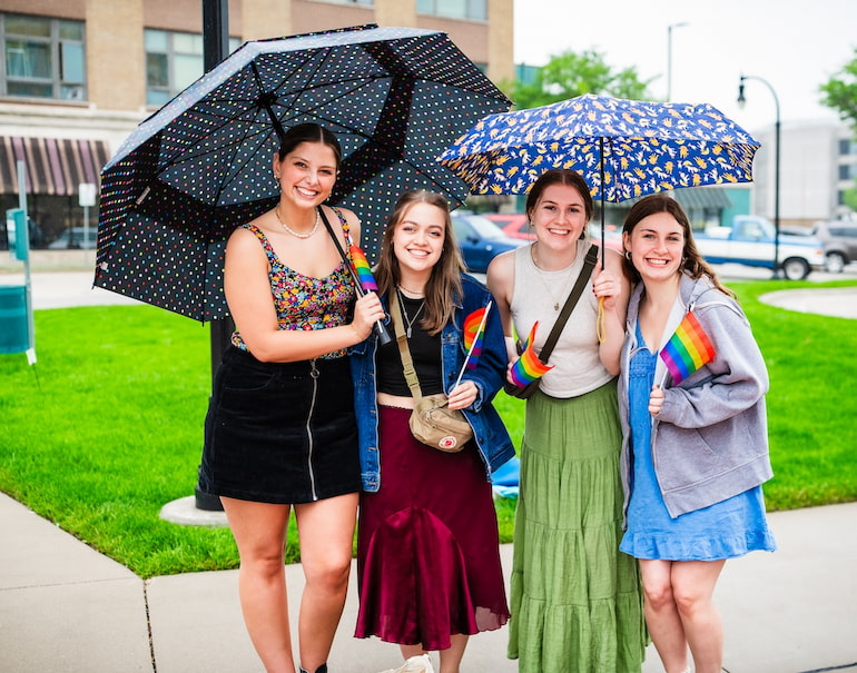 Ryenne Lacher, Nora Glover, Grace Hamann, Lauren Pawloski at Quad Cities Pride Festival on a rainy Saturday afternoon.