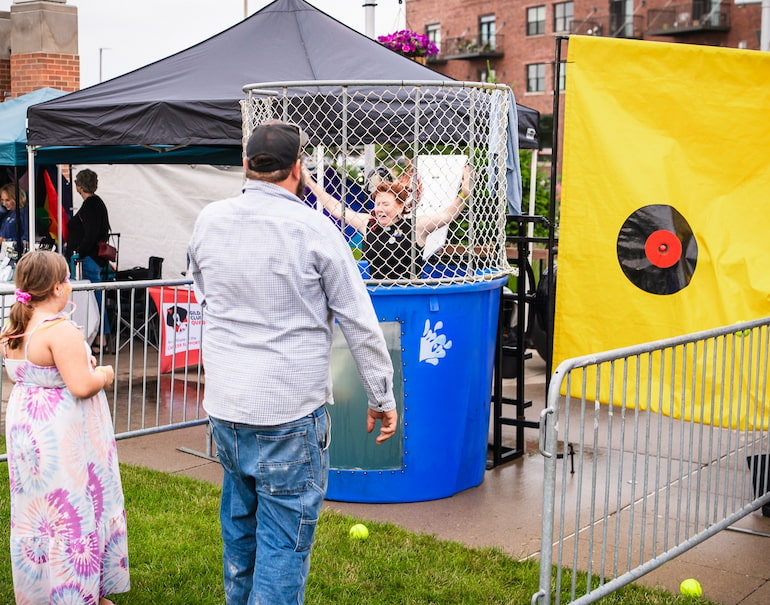 Sarah Jane Eikleberry, a professor at St. Ambrose University, is dunked by a festival-goer June 1 at Clock Inc.'s dunk tank at the Quad Cities Pride Festival.